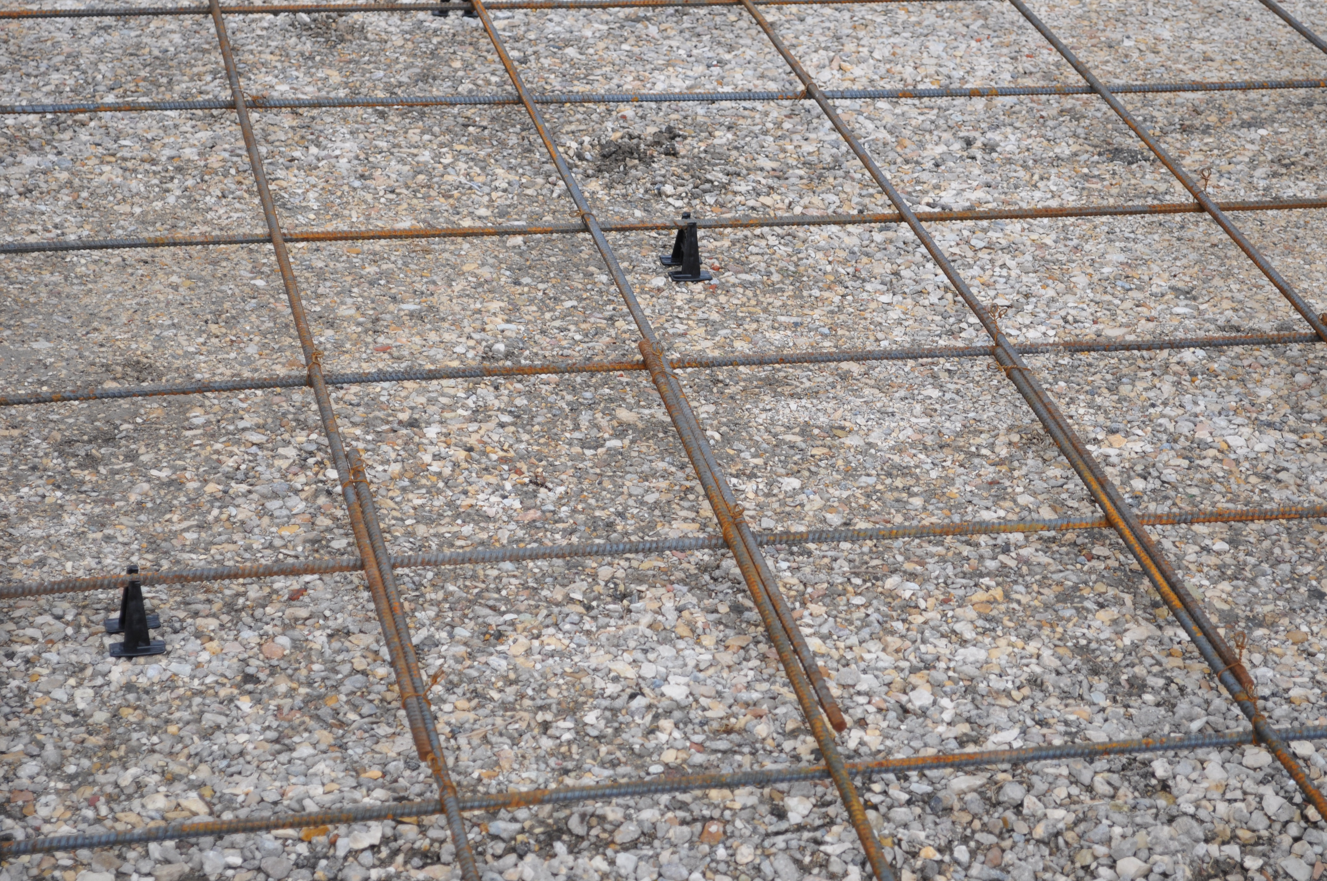 Close-up of a hand float smoothing wet concrete on a slab