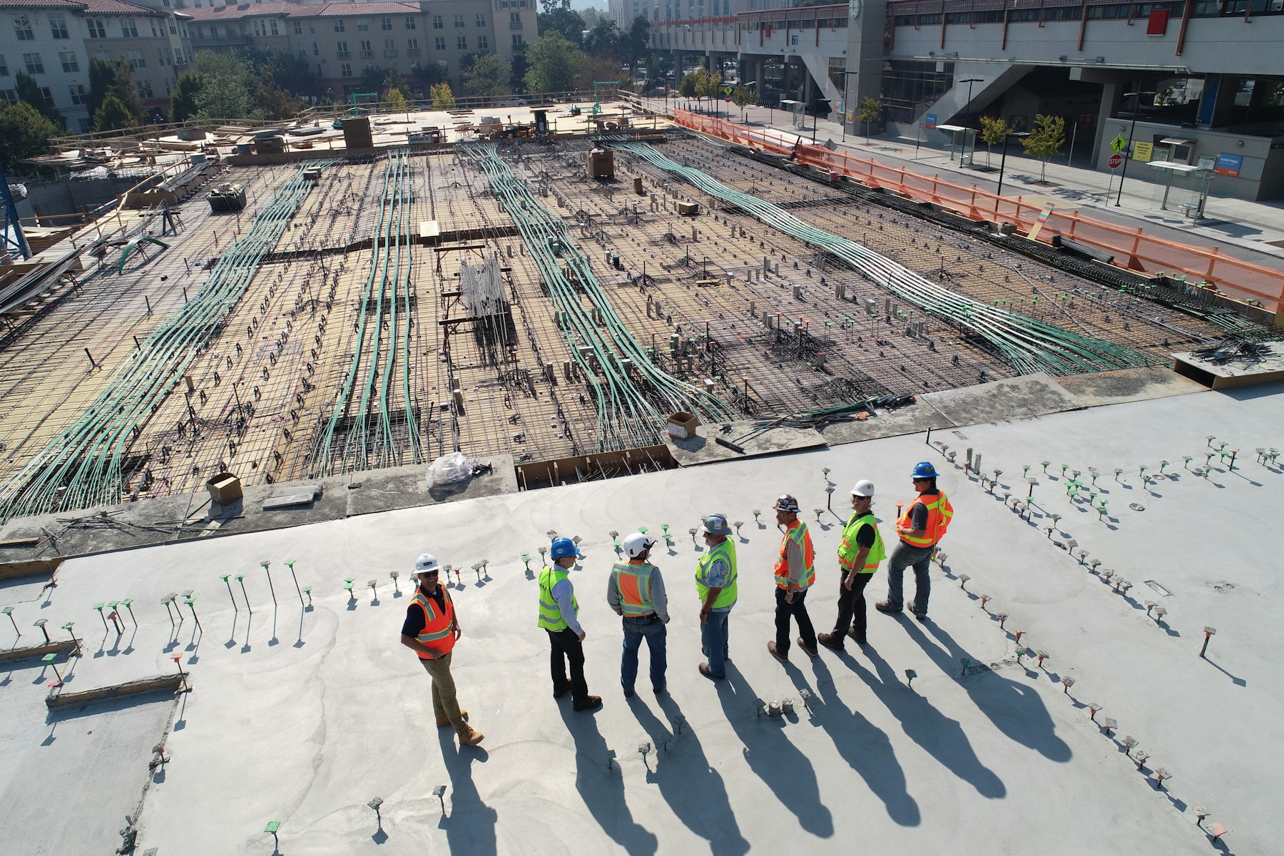 Crew pouring and screeding a concrete slab on a job site